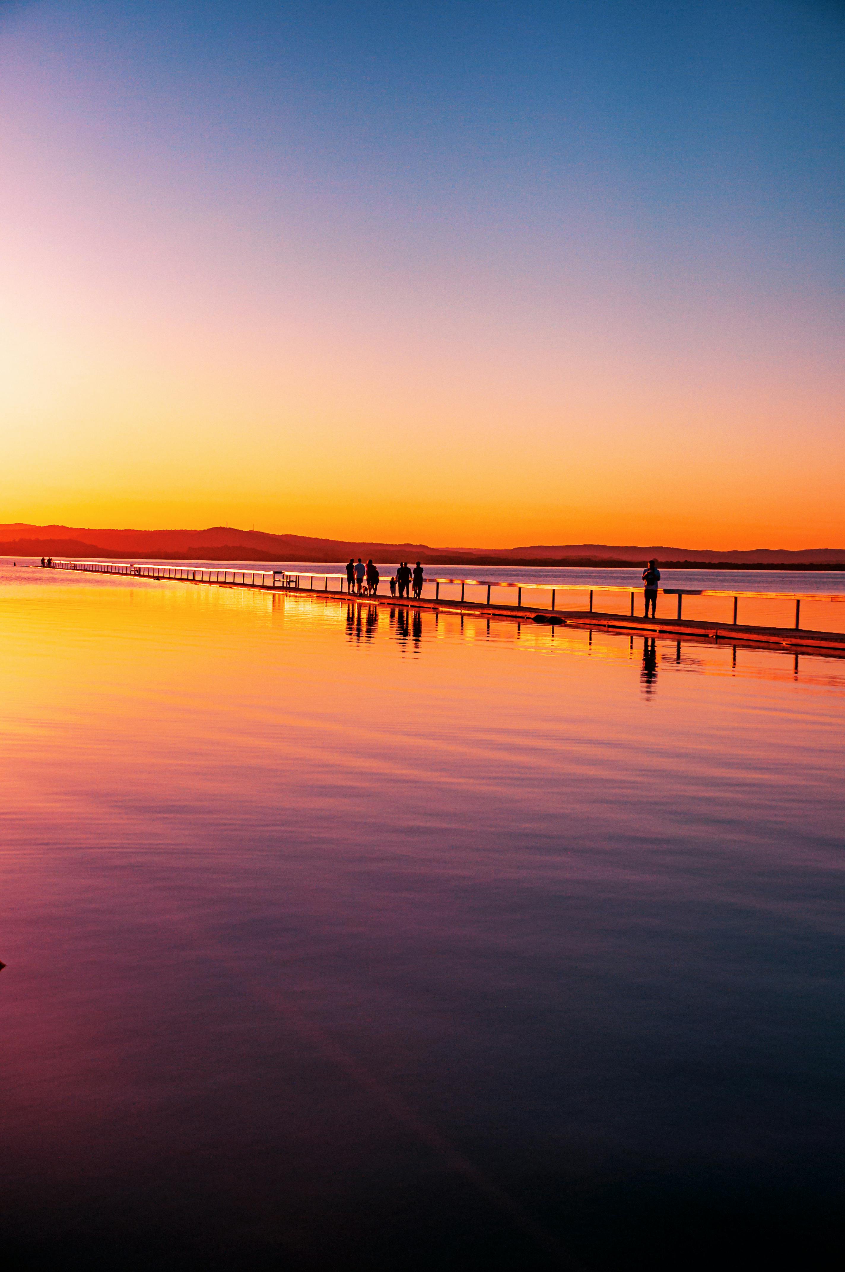 Person meditating peacefully at sunrise with a glowing lake view